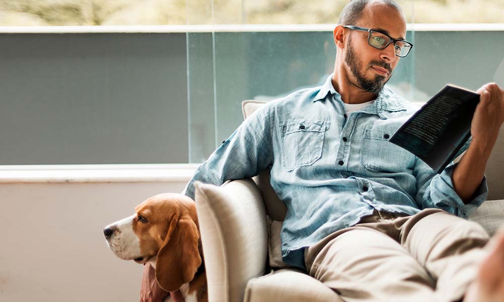 Successful man taking time to read and enjoy the time with his dog